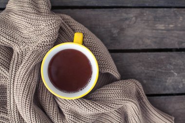 Bir fincan sıcak kakao, ahşap bir zemin üzerine örme şal. Kahvaltı. Rahat. Sonbahar