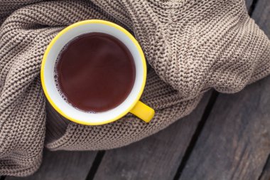 Bir fincan sıcak kakao, ahşap bir zemin üzerine örme şal. Kahvaltı. Rahat. Sonbahar