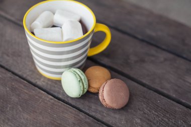 Ahşap bir masa üzerinde marshmallow ile sıcak kakao bir fincan. Bademli kurabiye. Tatlı. Kahvaltı. Rahat. Sonbahar.