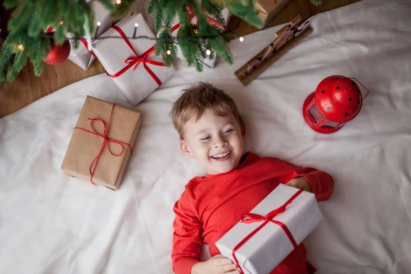 Маленький Щасливий Милий Хлопчик Лежить Біля Ялинки Тримає Подарункову Коробку — стокове фото