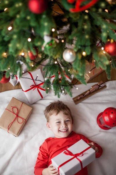 Маленький Щасливий Милий Хлопчик Лежить Біля Ялинки Тримає Подарункову Коробку — стокове фото