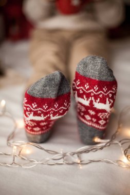 Yakın çekim. Noel çorap ayaklarda. Mutlu çocuk Noel ağacının yanında oturuyor. Tatil. Noel. Yeni yıl. Rahat. Kış.