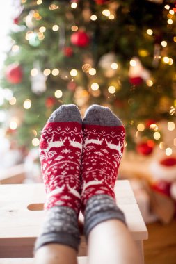 Yakın çekim. Yılbaşı çoraplı kadın ayak Noel ağacı yakınındaki. Tatil. Rahat.