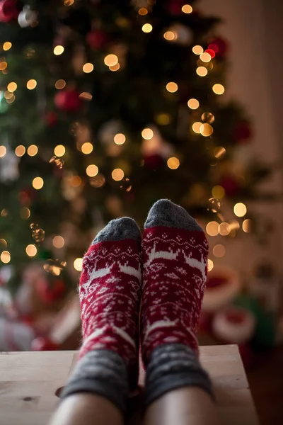 Close-up. Pés de mulher em meias de Natal perto da árvore de Natal. Férias. Aconchegante . — Fotografia de Stock