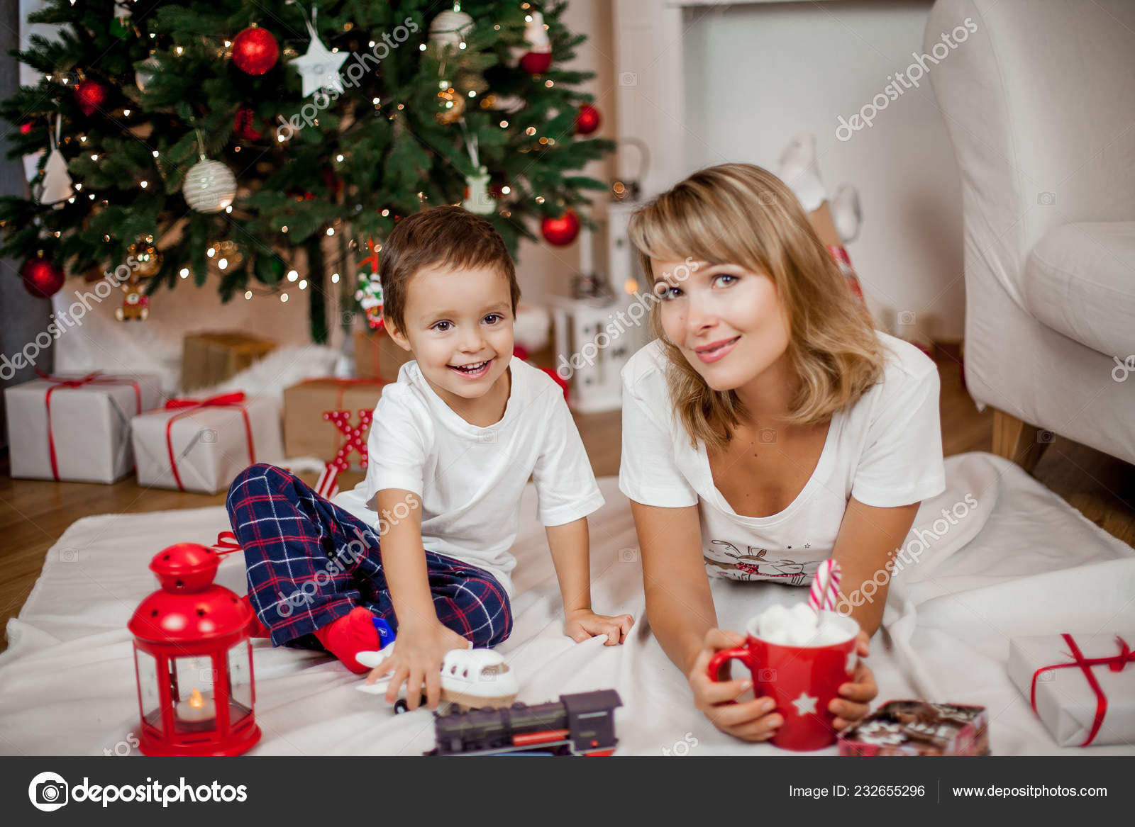 A Young Mother And Son Playing Near The Christmas Tree Family In