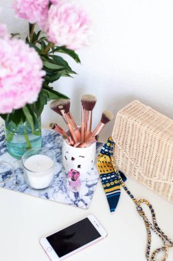 Peonies. Buket pembe peonies, mum, hasır çanta, eşarp, parfüm, takı, beyaz masa kozmetik masada telefon