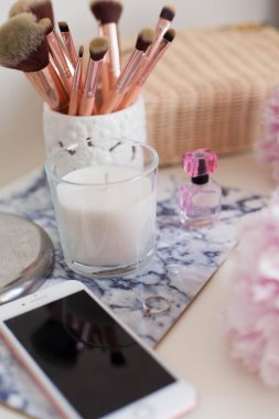 Peonies. Buket pembe peonies, mum, hasır çanta, eşarp, parfüm, takı, beyaz masa kozmetik masada telefon