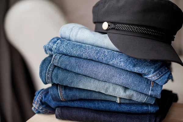 Jeans, black cap, denim cotton, blue. Stack of jeans in the interior. Clothing. Spring.