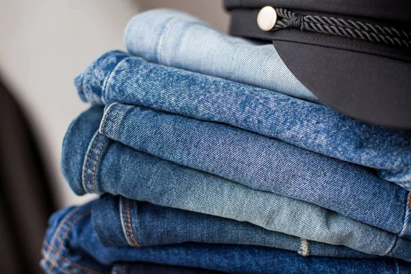 Jeans, black cap, denim cotton, blue. Stack of jeans in the interior. Clothing. Spring.