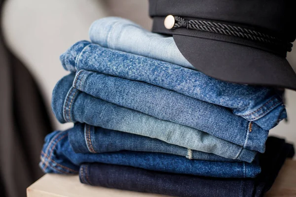 Jeans, black cap, denim cotton, blue. Stack of jeans in the interior. Clothing. Spring.