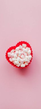 Marshmallow pembe bir arka plan üzerinde kırmızı kalp şekli. Sevgililer günü. Aşk.