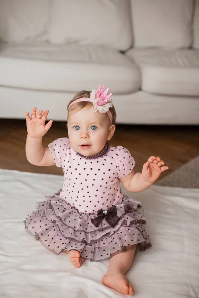 かわいい青い目の少女彼女の頭の上の王冠とピンクのドレス 家で赤ちゃんの肖像画 居心地の良い 誕生日 — ストック写真