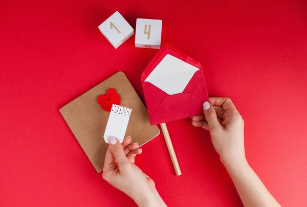 女性手在红色背景上签名 情人节的概念 情人节 木制立方体与数字 — 图库照片