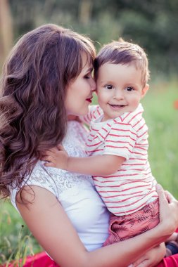 Güzel bir aile haşhaş alanına yürüyor. Küçük oğlu olan genç bir anne yürüyor. Yaz. Bahar.