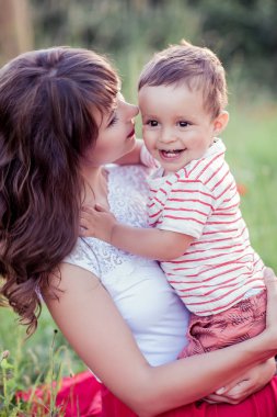 Güzel bir aile haşhaş alanına yürüyor. Küçük oğlu olan genç bir anne yürüyor. Yaz. Bahar.