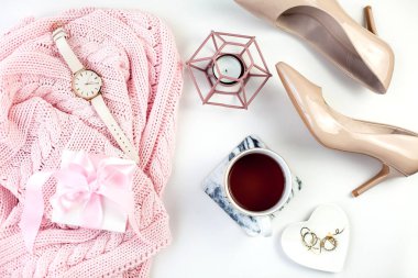 Bahar dekor. Bayan giyim. İzle, hediye kutusu ile pembe kurdele, Ayakkabı, takı, bir mum, bir fincan çay beyaz bir arka plan üzerinde.