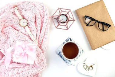 Bahar dekor. Bayan giyim. İzle, pembe bir kurdele, takı, bir mum, bir fincan çay beyaz bir arka plan üzerinde hediye kutusu.