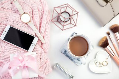 Bahar dekor. Bayan giyim. Beyaz bir arka plan üzerinde izlemek, hediye kutusu ile pembe bir kurdele, takı, bir mum, bir bardak çay, gözlük, çanta.