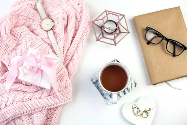 Spring decor. Womens clothing. Watch, gift box with a pink ribbon, jewelry, a candle, a mug of tea on a white background.