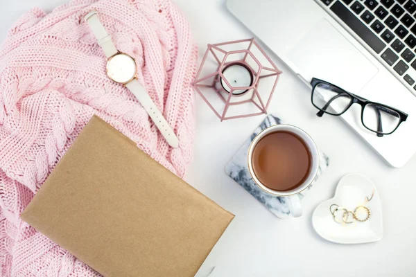 Arredo primaverile. Abbigliamento donna. Guarda, confezione regalo con un nastro rosa, gioielli, una candela, una tazza di tè, bicchieri, un quaderno su sfondo bianco . — Foto Stock