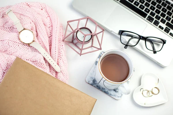 Spring decor. Womens clothing. Watch, gift box with a pink ribbon, jewelry, a candle, a mug of tea, glasses, a notebook on a white background.