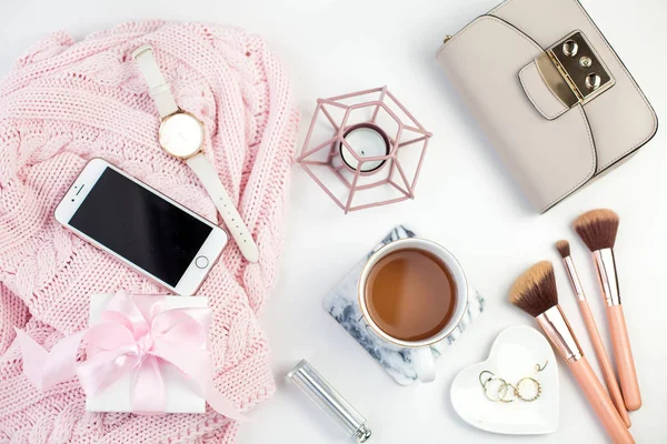 Spring decor. Womens clothing. Watch, gift box with a pink ribbon, jewelry, a candle, a mug of tea, glasses, bag on a white background.