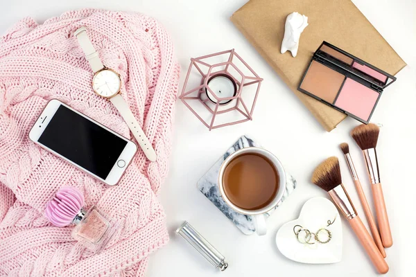 Spring decor. Womens clothing. Watch, gift box with a pink ribbon, jewelry, a candle, a mug of tea, cosmetics on a white background.