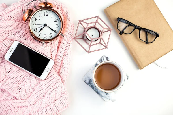 Spring decor. Women\'s clothing. Alarm clock, candle, tea mug, glasses, notebook on a white background. Spring.