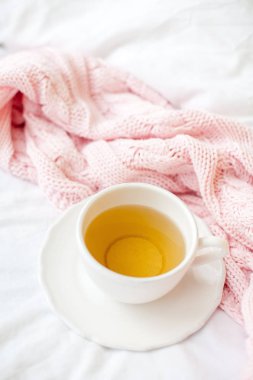 Güzel beyaz fincan çay yatakta, pembe örgü şal ile. Yatakta kahvaltı. Sabah. Bahar.