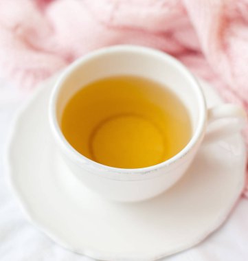 Güzel beyaz fincan çay yatakta, pembe örgü şal ile. Yatakta kahvaltı. Sabah. Bahar.