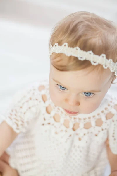 Portrét holčičky krásný modrooký v bílé pletené šaty. Něha. — Stock fotografie