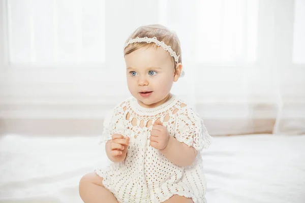 Portrait of a beautiful blue-eyed little girl in a white knitted dress. Tenderness. — Stock Photo, Image