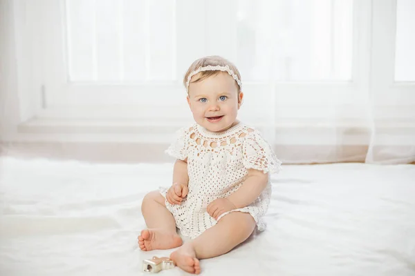 Portrait of a beautiful blue-eyed little girl in a white knitted dress. Tenderness. — Stock Photo, Image