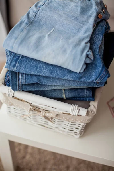 Jeans in a white wicker basket. — Stock Photo, Image