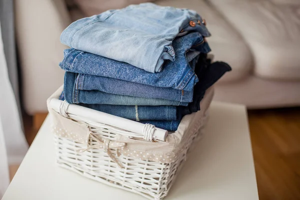 Jeans in a white wicker basket. — Stock Photo, Image