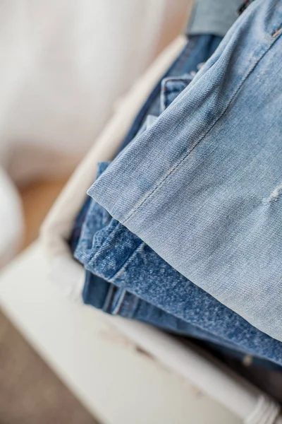 Close-up. Jeans in a white wicker basket. — Stock Photo, Image