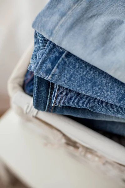 Close-up. Jeans in a white wicker basket. — Stock Photo, Image