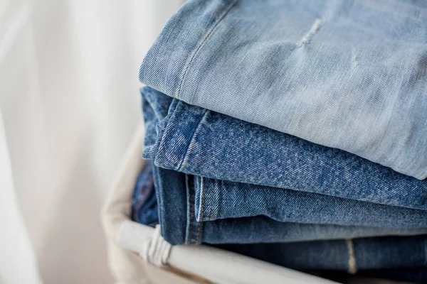 Close-up. Jeans in a white wicker basket. — Stock Photo, Image