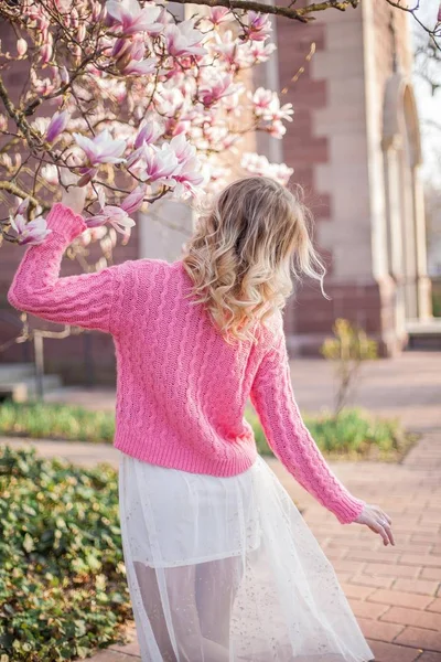 Porträt einer schönen jungen Frau in der Nähe einer Magnolie. Frühling. — Stockfoto
