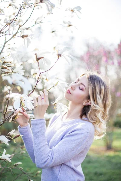 Portrait of a beautiful young woman near a magnolia. Spring. — Stock Photo, Image