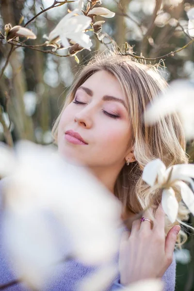 Retrato de uma bela jovem perto de uma magnólia. Primavera . — Fotografia de Stock