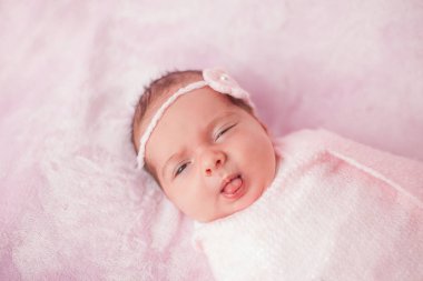 Pembe bir arka planda pembe bir takım elbiseli küçük yenidoğan bebek. Annelik.