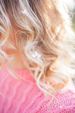 Close. Çiçekli bir ağacın yanında genç bir sarışının bahar portresi. Mutlu genç kadın.