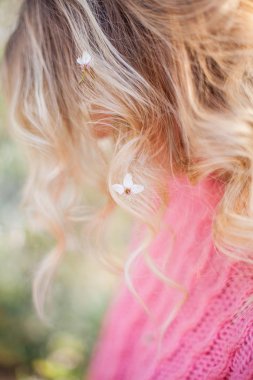 Close. Çiçekli bir ağacın yanında genç bir sarışının bahar portresi. Mutlu genç kadın.