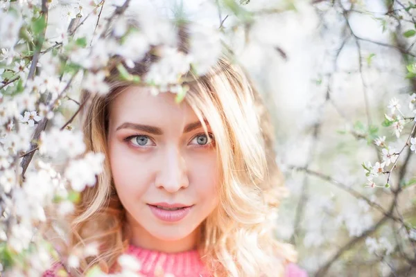 Retrato de primavera de uma jovem loira perto de uma árvore florida. Jovem feliz . — Fotografia de Stock