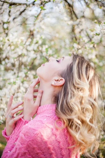 Retrato de primavera de uma jovem loira perto de uma árvore florida. Jovem feliz . — Fotografia de Stock