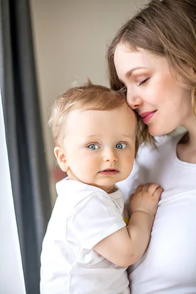 Beautiful mother and little son 9 months in the home interior. Cozy. Baby. Motherhood. — Stock Photo, Image