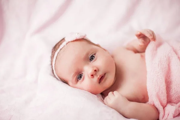 Kleines neugeborenes Baby im rosa Anzug auf rosa Hintergrund. Mutterschaft. — Stockfoto