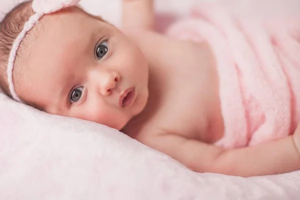 Маленький новорожденный в розовом костюме на розовом фоне. Материнство . — стоковое фото
