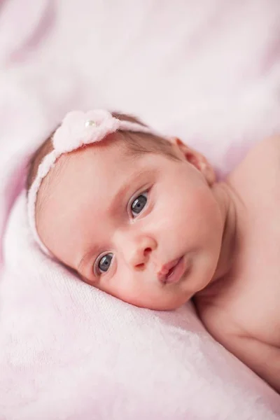 Malé novorozené dítě v růžovém obleku na růžovém pozadí. Mateřství. — Stock fotografie